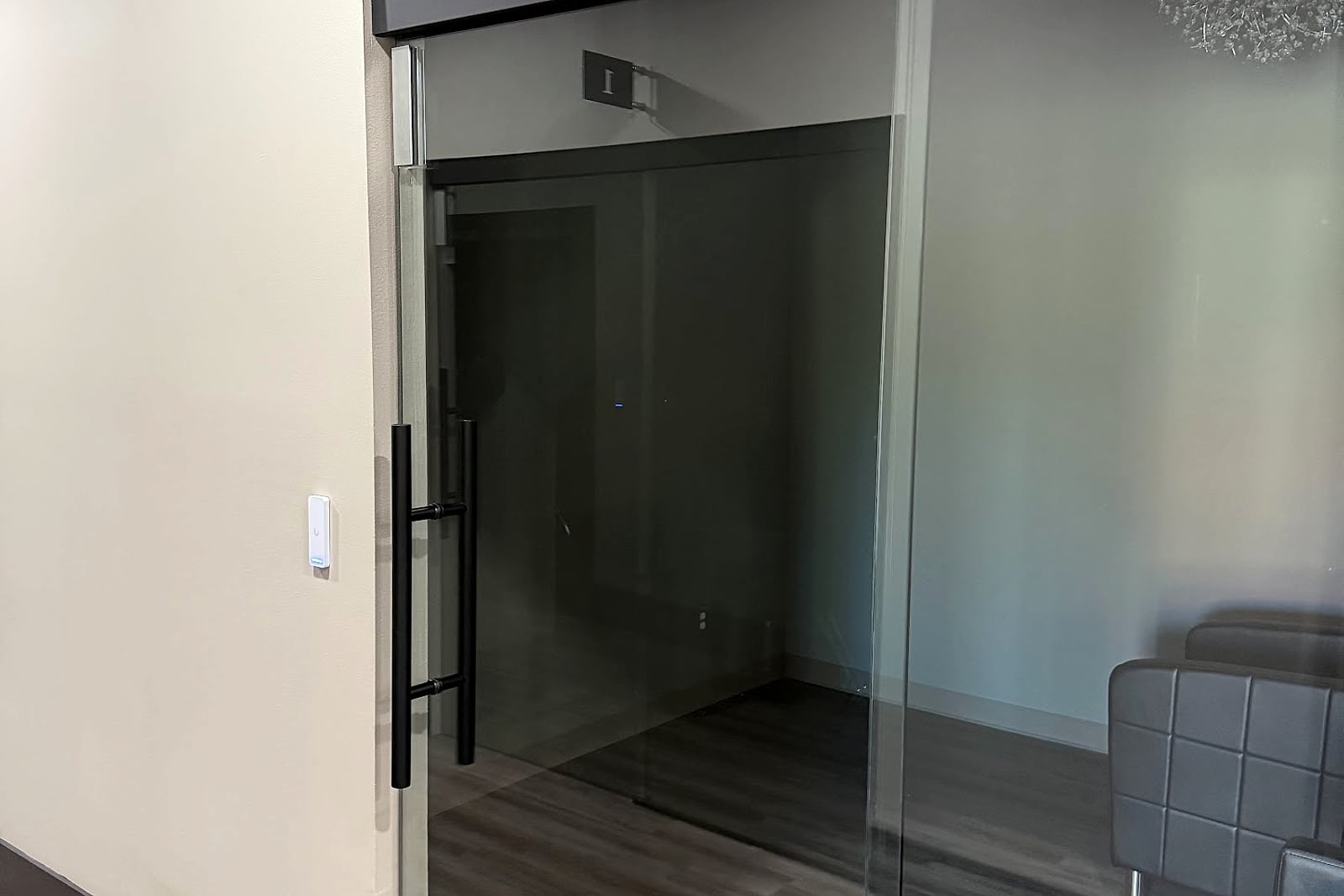 Glass office door with a discreet wall-mounted access reader.