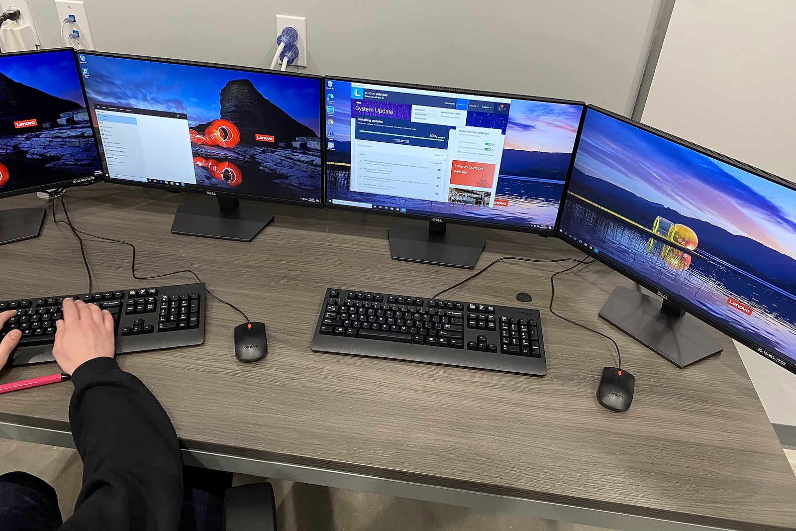 Technician updating several business workstations across multiple displays.