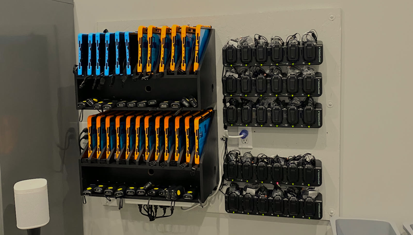 Rugged tablets, handheld scanners, and radios organized in charging stations.